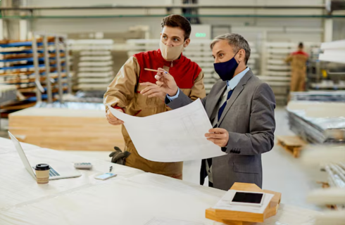 Engineers discussing plans in factory